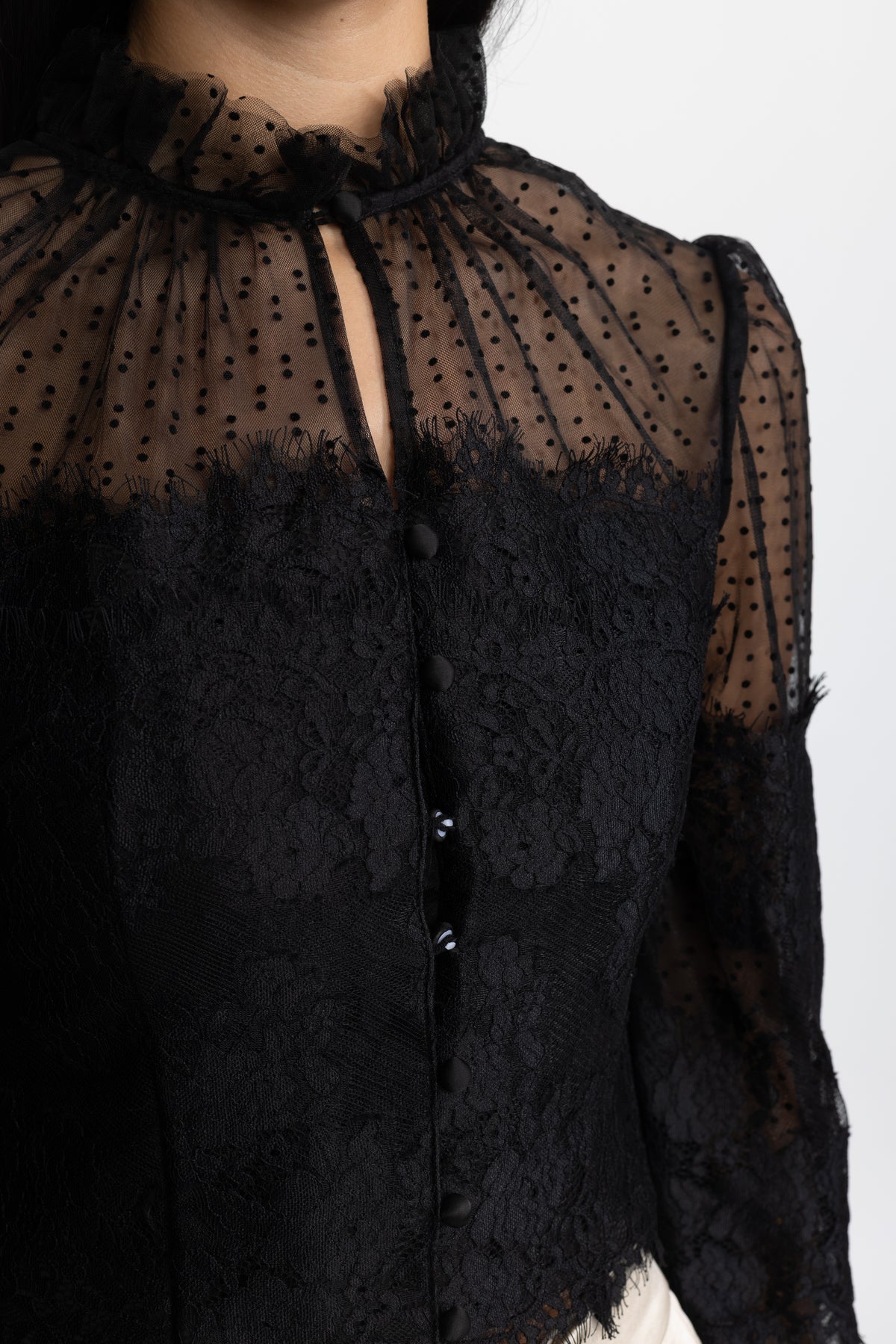 Blouse courte noire en dentelle et tulle plumetis à col volanté 