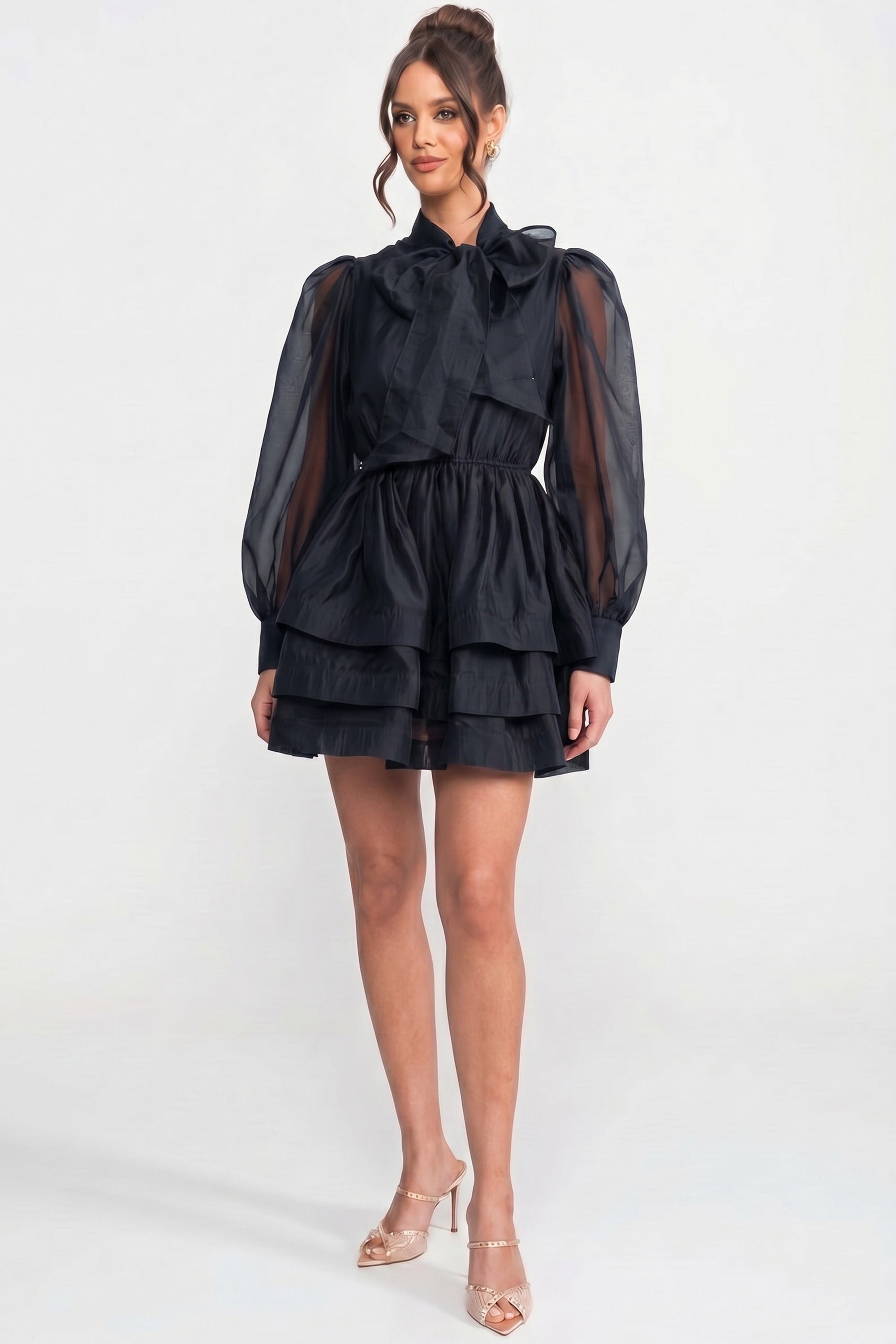 Mini-robe noire à col montant, manches bouffantes, jupe à volants superposés et nœud 
